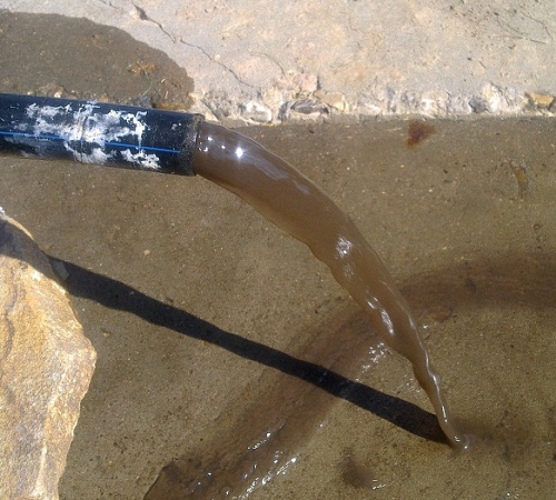 Грязная вода из только что пробуренной скважины Вода из непромытой скважины